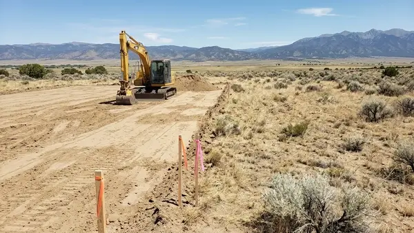 Excavator working within a defined area while adjacent ground remains undisturbed for future rural property improvements