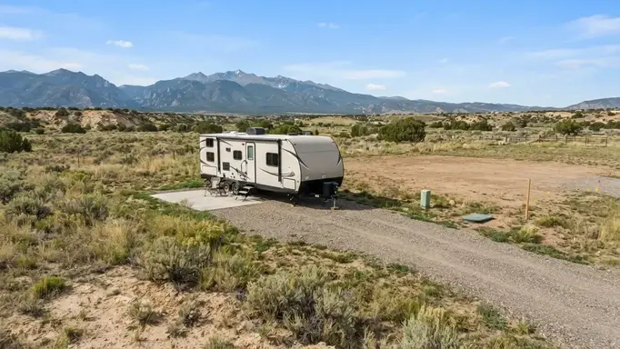 RV parked on rural Costilla County acreage with gravel access and space planned for future homesite and septic infrastructure