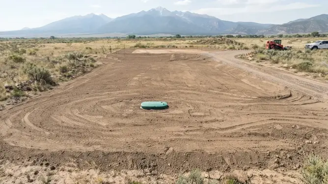 Completed rural septic installation area restored with finished grading and access on a Costilla County property