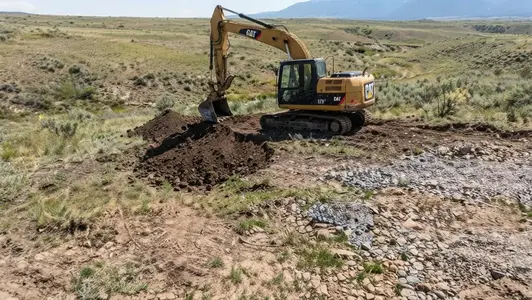 Rural Costilla County Colorado excavation site showing varied terrain, gravelly ground, and elevation changes